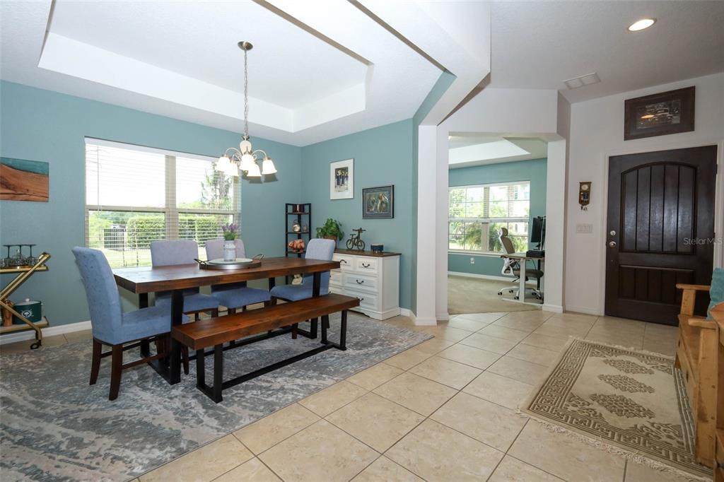 A dining room with a wooden table, blue chairs, and a bench on a rug — 5232 VILLA ROSA AVENUE, ST CLOUD, FL