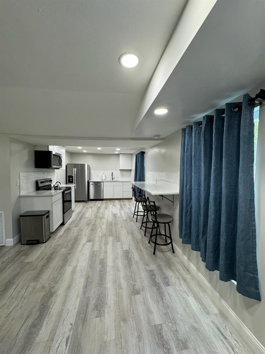 A modern kitchen features white cabinets, stainless steel appliances, and a long breakfast bar — 4679 SE Ebbtide Avenue # O, Stuart FL 34997, STUART, FL