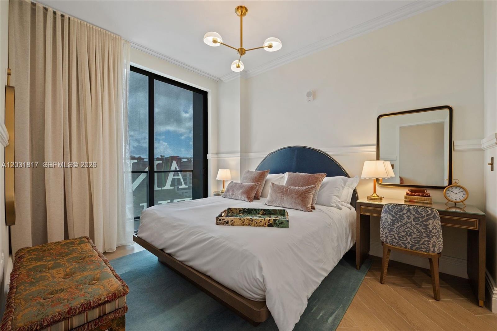 A bedroom features a blue headboard, a desk with a mirror, and a balcony view — 2700 NW 2ND AVE # 417, Miami FL 33127, MIAMI, FL