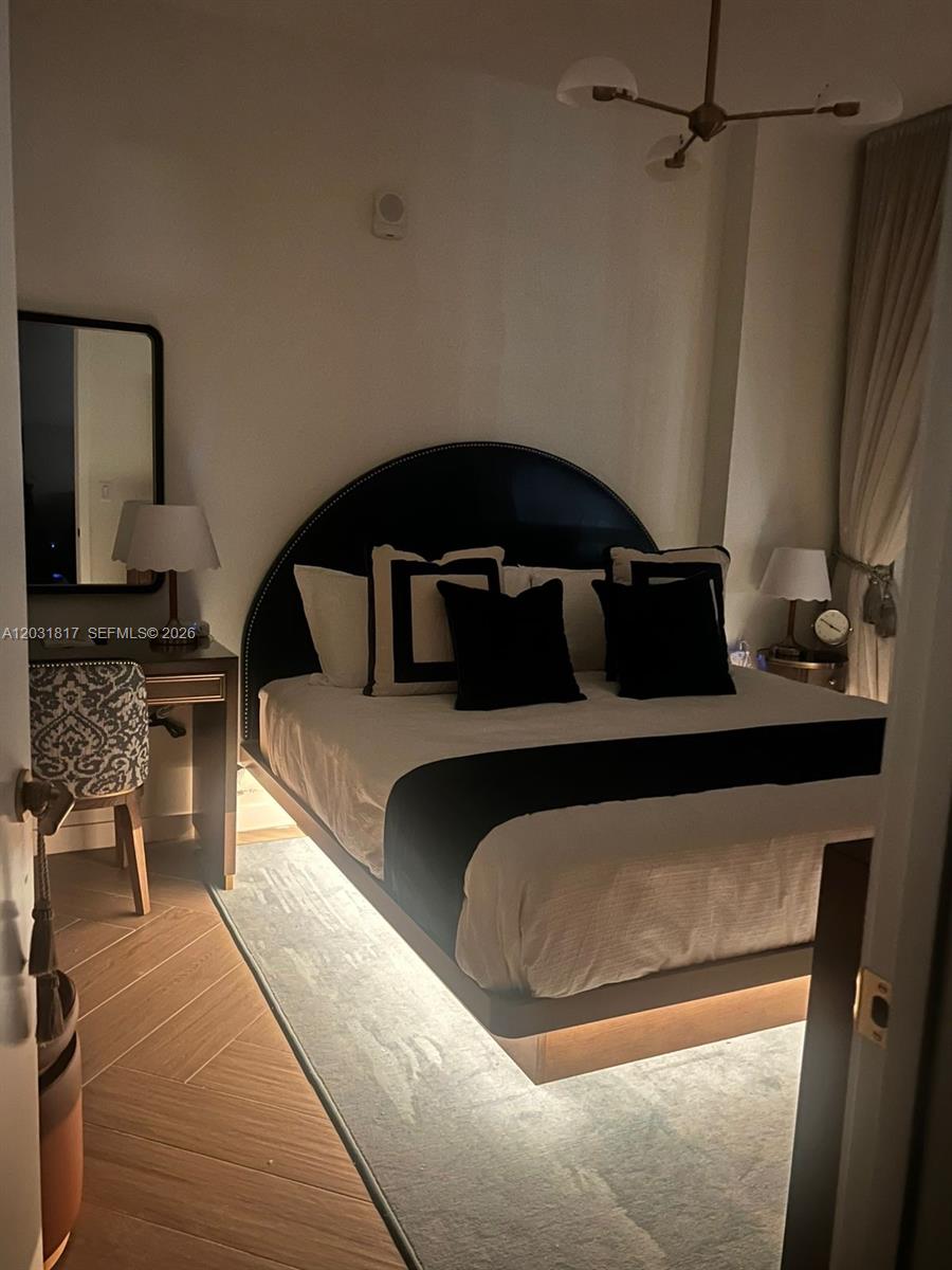 A bedroom features a platform bed with under-lighting, a dark headboard, and a small desk — 2700 NW 2ND AVE # 417, Miami FL 33127, MIAMI, FL
