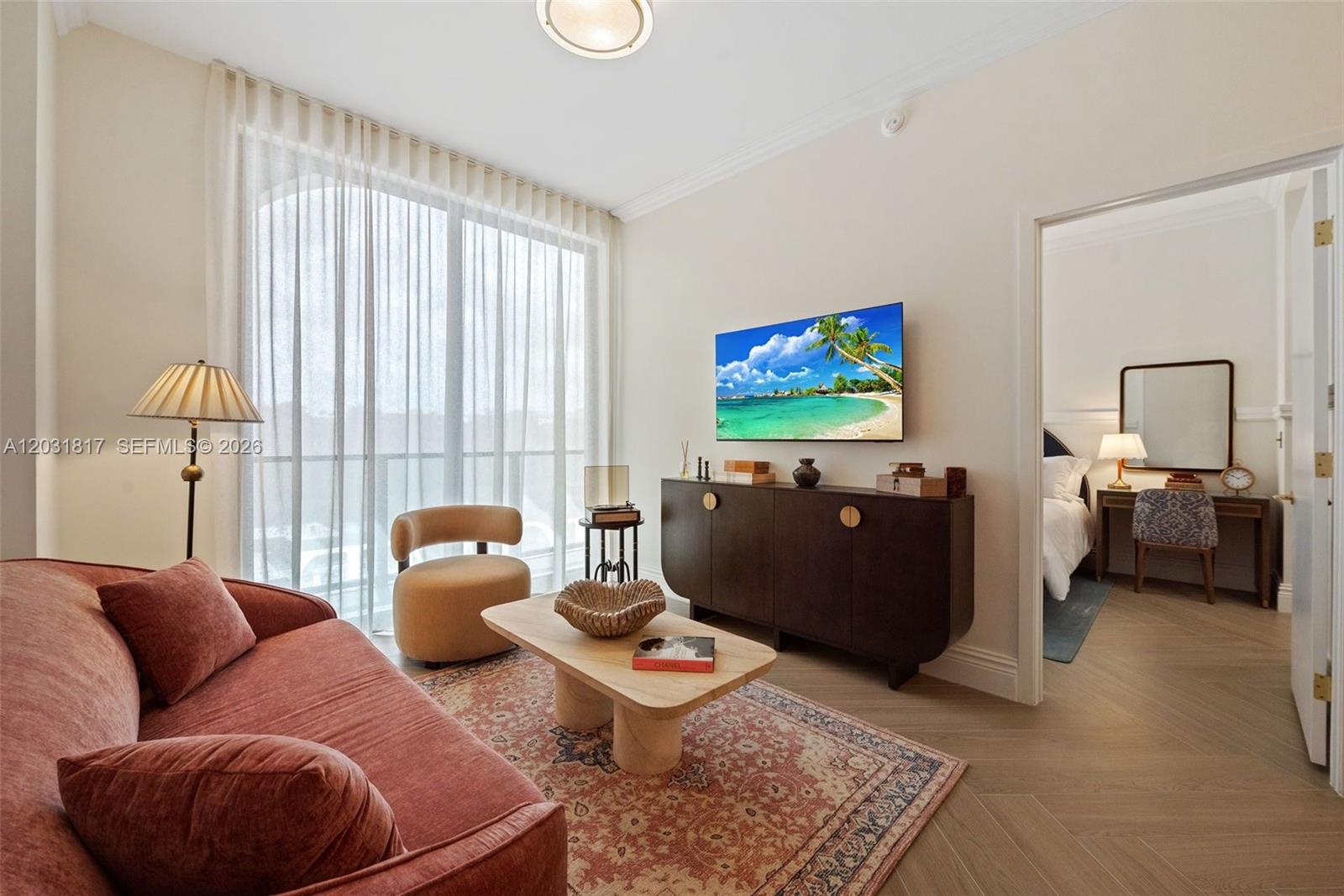 A living room features a rust-colored sofa, a wooden coffee table, and a dark sideboard — 2700 NW 2ND AVE # 417, Miami FL 33127, MIAMI, FL