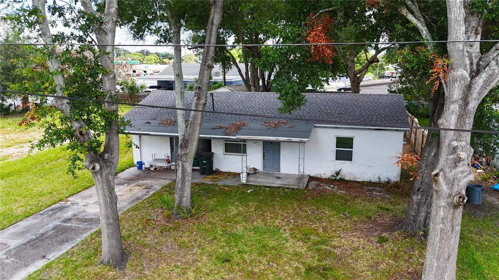 An aerial view shows a single-story white house with a dark roof and surrounding trees — 721 S WOODLAND STREET, WINTER GARDEN, FL