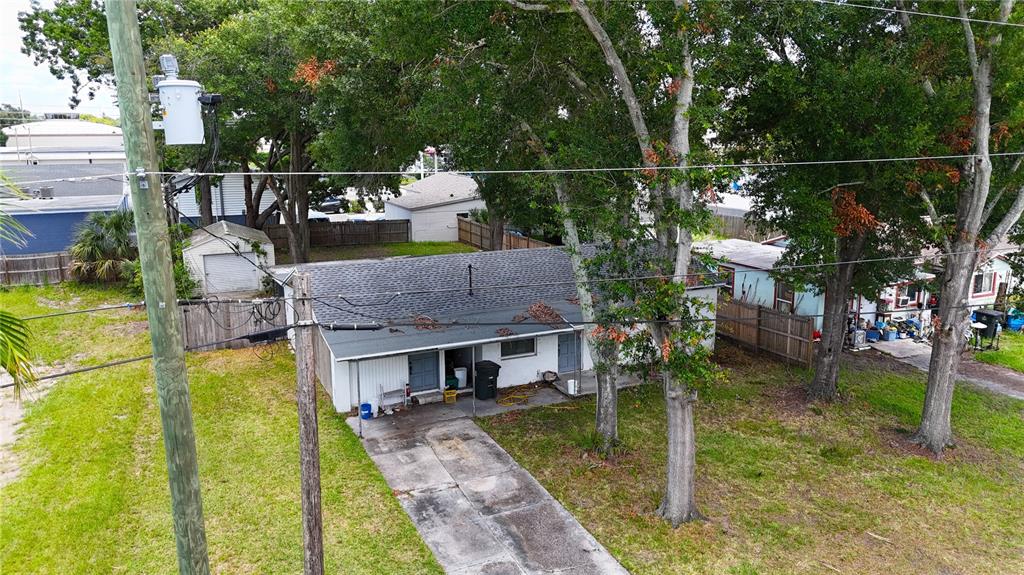 An aerial view shows a single-story house with a concrete driveway and surrounding trees — 721 S WOODLAND STREET, WINTER GARDEN, FL
