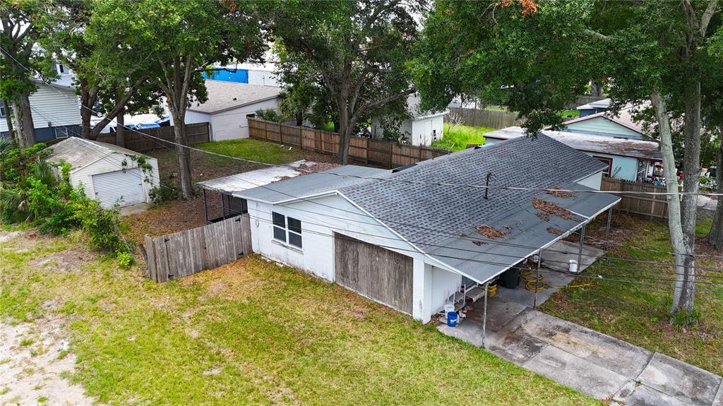 An aerial view of a white house with a garage, carport, and detached shed — 721 S WOODLAND STREET, WINTER GARDEN, FL