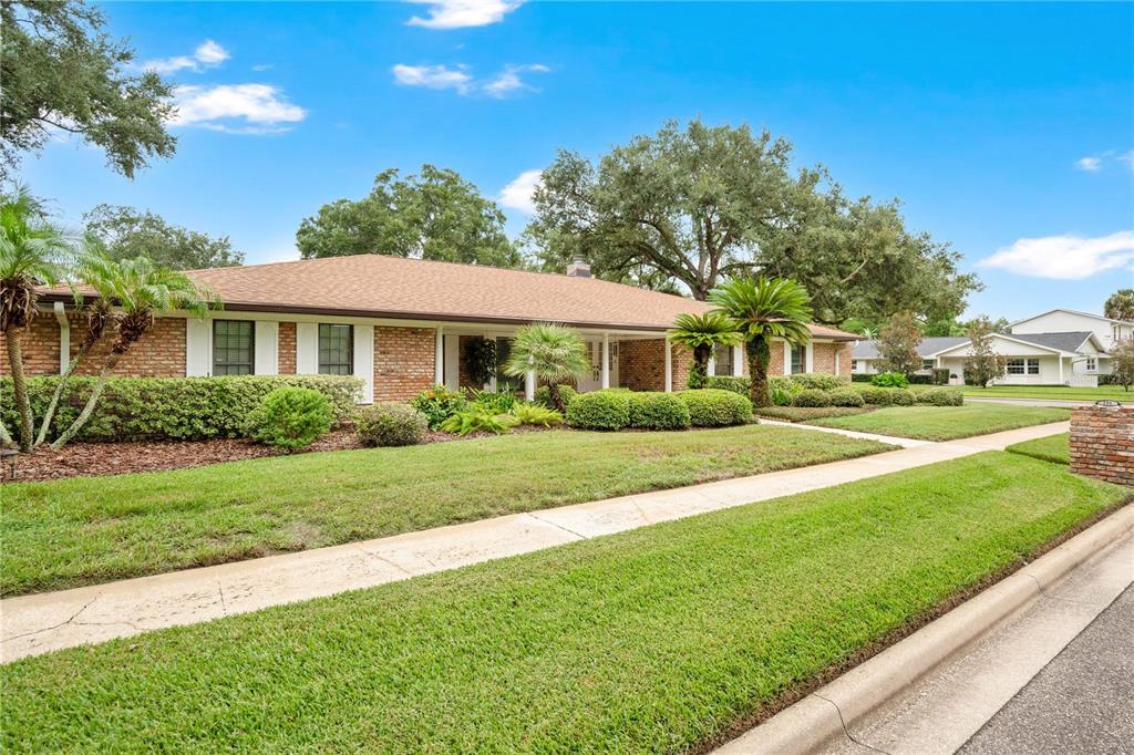A single-story brick house with a low-pitched roof, manicured lawn, and mature landscaping — 231 WHITE OAK CIRCLE, MAITLAND, FL