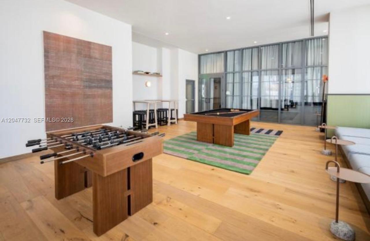 A game room features a foosball table, a pool table, and light wood flooring — 11 NE 6th St # 213, Miami FL 33132, MIAMI, FL