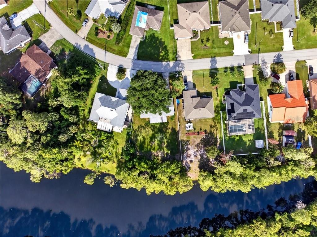 Aerial view of suburban houses along a curved road bordering a body of water — 40 BOULDER ROCK DRIVE, PALM COAST, FL