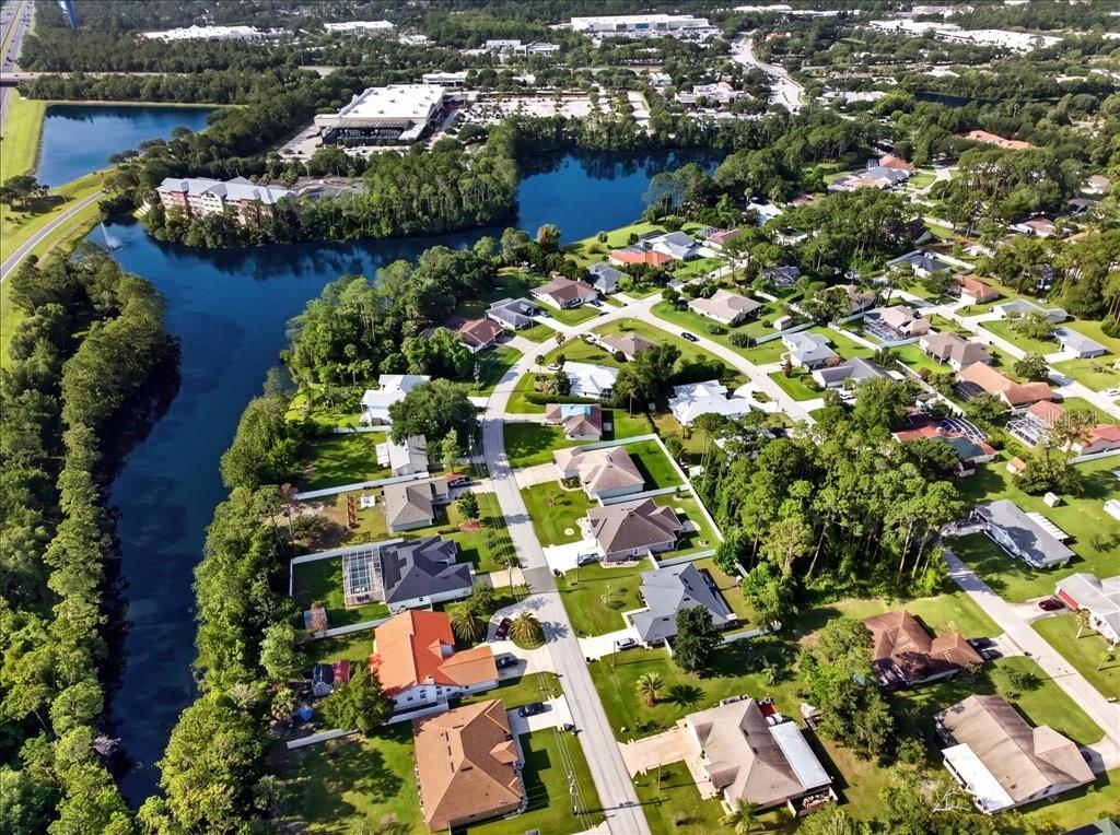An aerial view shows a residential neighborhood situated along a lake and wooded area — 40 BOULDER ROCK DRIVE, PALM COAST, FL