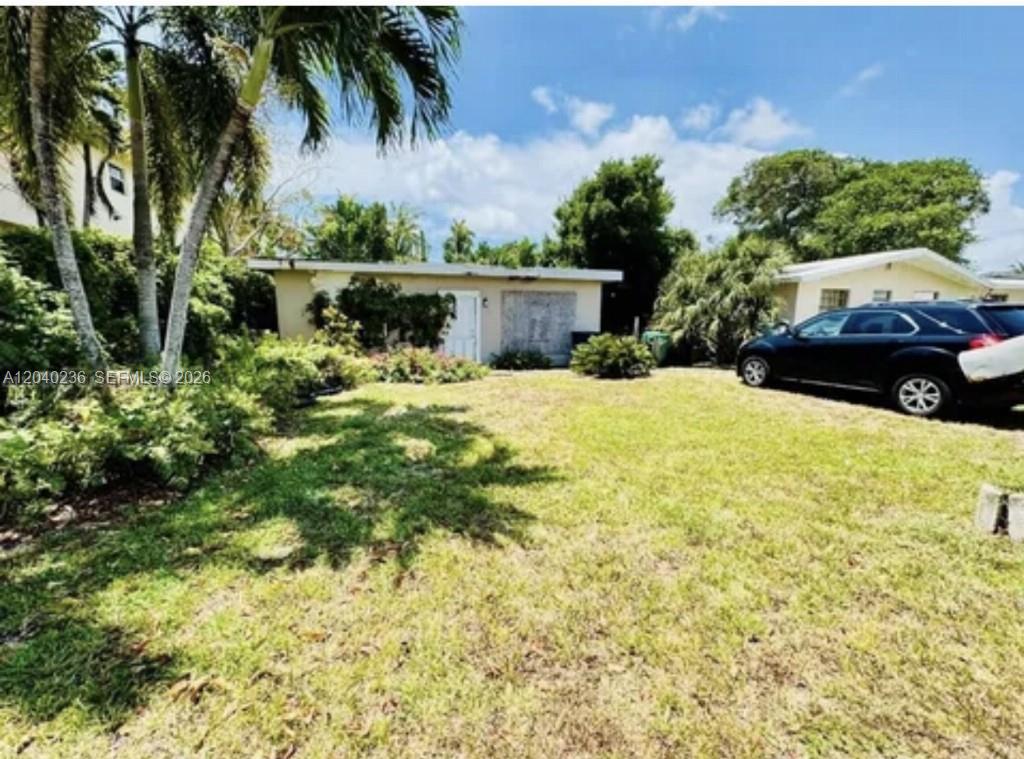 A single-story house with a grassy front yard and a parked black SUV — 2616 NE 214th St, Miami FL 33180, MIAMI, FL