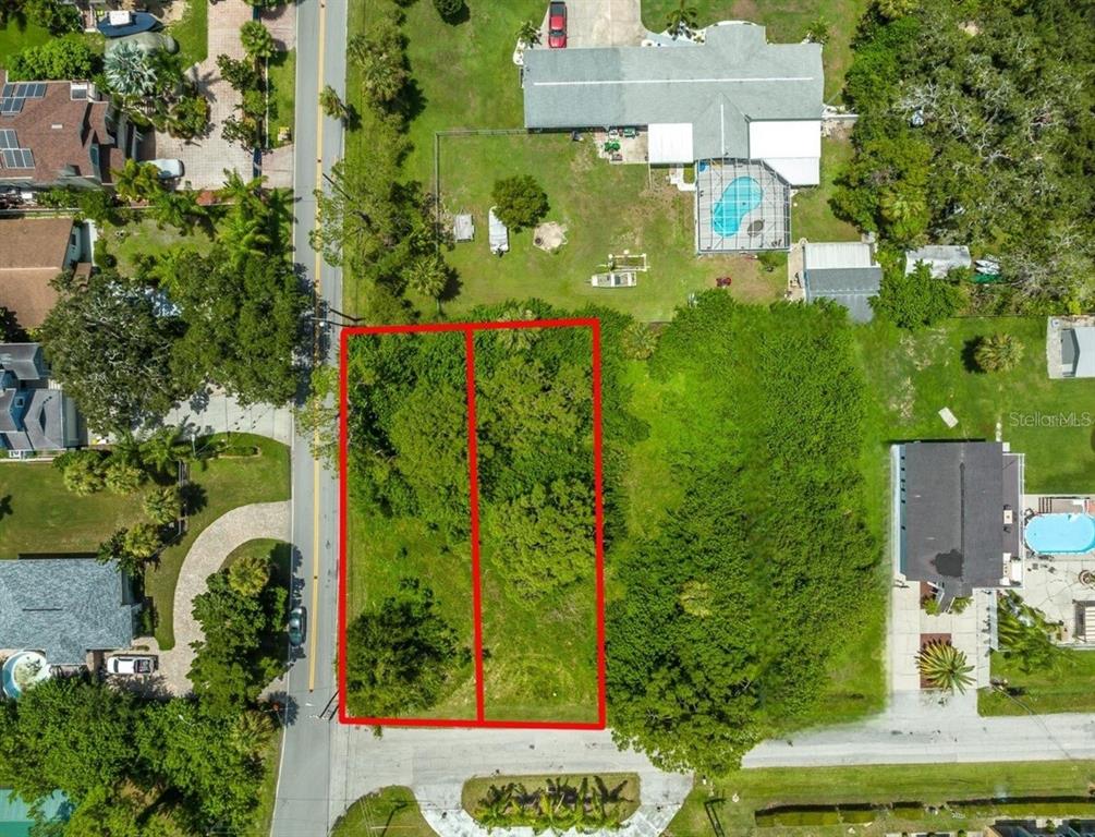 An aerial view shows two adjacent, undeveloped, tree-covered rectangular lots bordered by a paved road — 6307 OELSNER STREET UNIT 11&12, NEW PORT RICHEY, FL