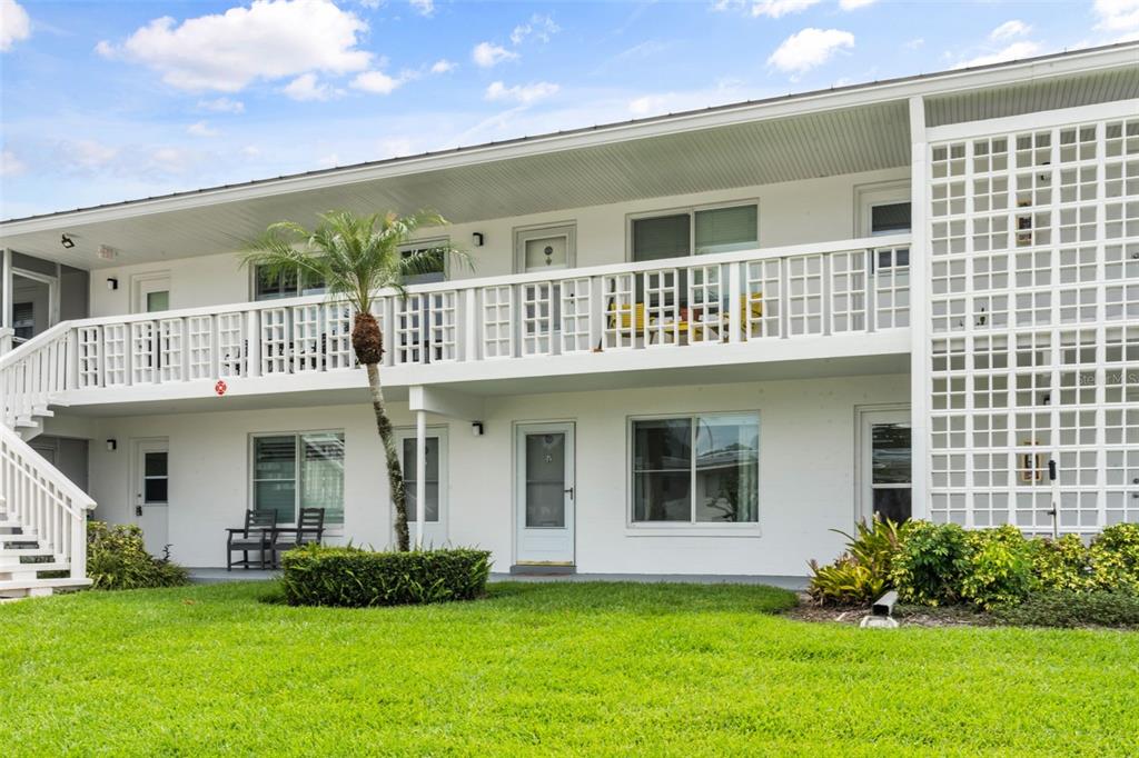 A two-story white apartment building features exterior walkways, a palm tree, and a grassy lawn — 1140 S ORLANDO AVENUE UNIT G-3, MAITLAND, FL