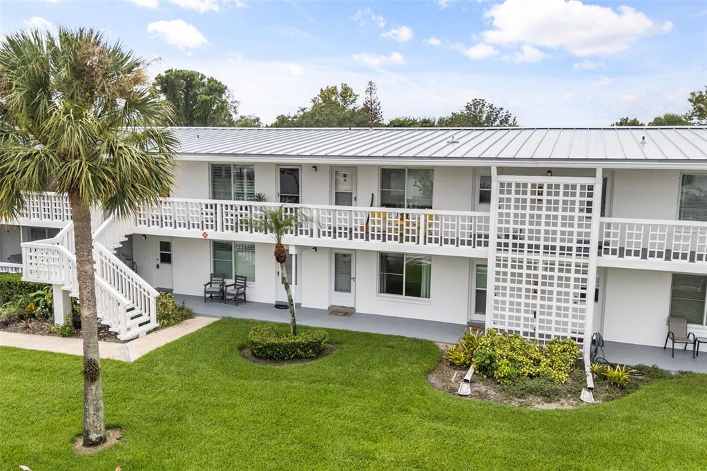 A two-story apartment building with white exterior walls, a metal roof, and a palm tree — 1140 S ORLANDO AVENUE UNIT G-3, MAITLAND, FL