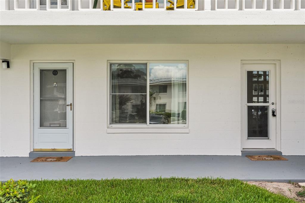 A white exterior wall features two doors flanking a large sliding window above a walkway — 1140 S ORLANDO AVENUE UNIT G-3, MAITLAND, FL