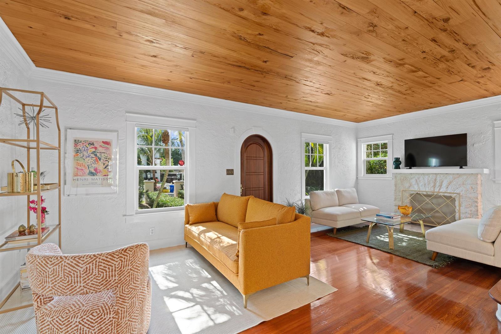 A living room features a wood-plank ceiling, white textured walls, hardwood floors, and a fireplace — 727 Claremore Drive, West Palm Beach FL 33401, WEST PALM BEACH, FL