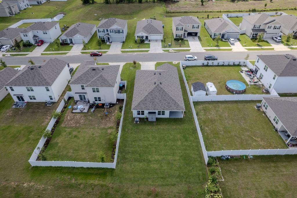 An aerial view shows several suburban houses with fenced backyards and a street in front — 17070 NW 176TH WAY, ALACHUA, FL