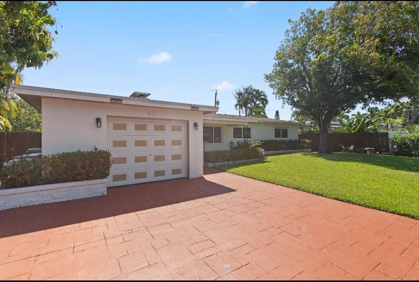 A single-story house with a white exterior, a garage, and a red paved driveway — 570 SE 2nd Avenue, Pompano Beach FL 33060, POMPANO BEACH, FL