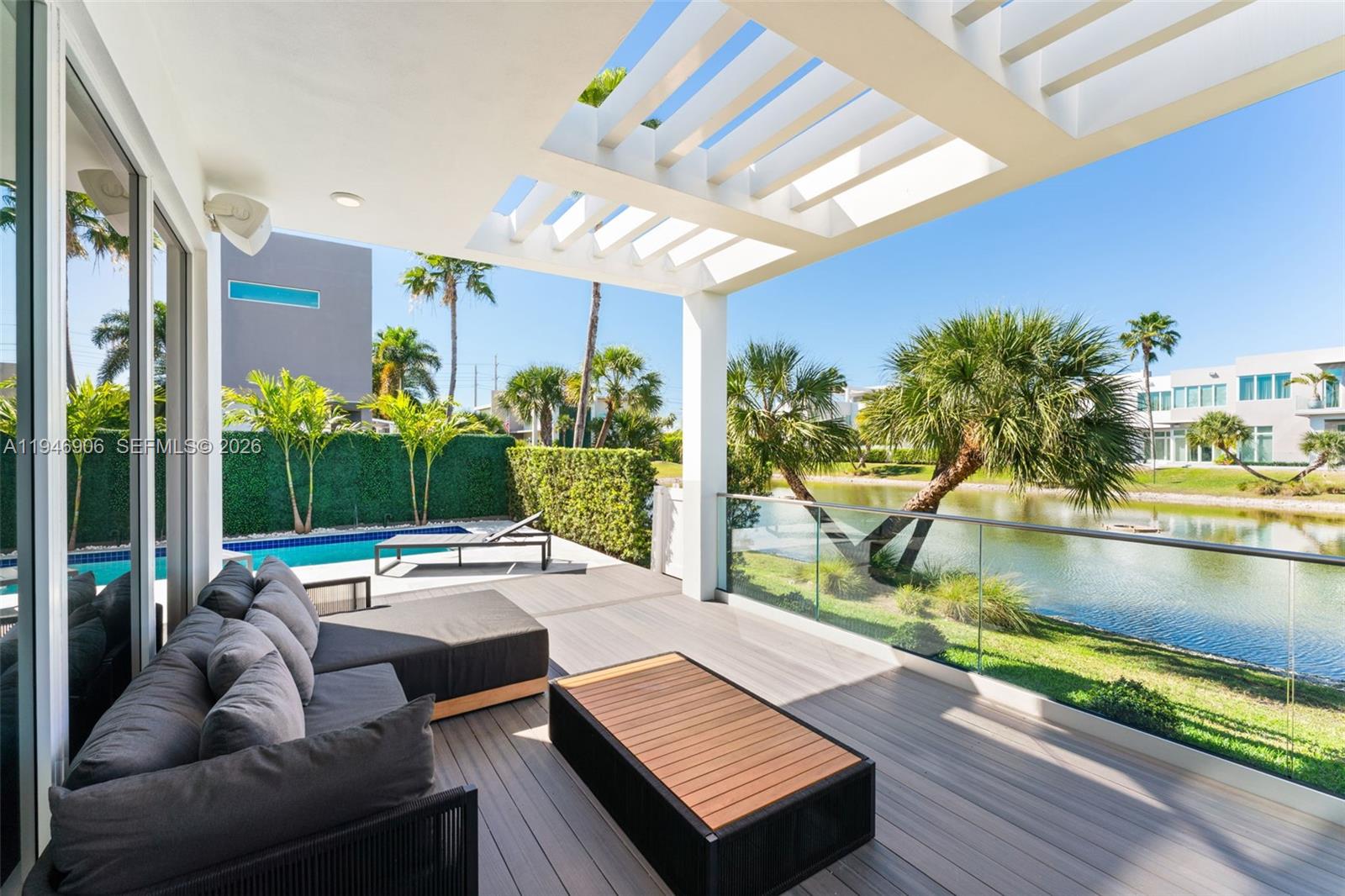 A modern living room features a large green wall sculpture, high ceilings, and mirrored walls — 10561 NW 67th Ter, Doral FL 33178, DORAL, FL