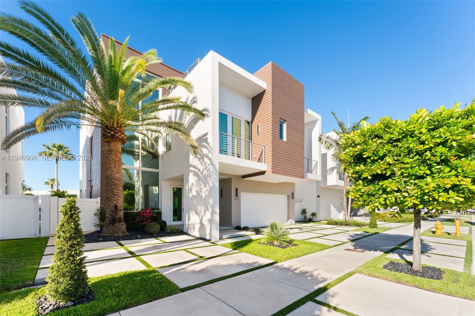A modern patio features a gray sectional sofa, a coffee table, and a pool overlooking water — 10561 NW 67th Ter, Doral FL 33178, DORAL, FL