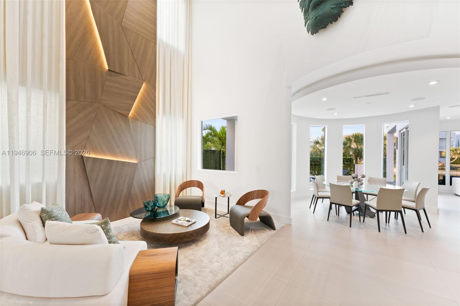 A modern living and dining area features a geometric wood accent wall with integrated lighting — 10561 NW 67th Ter, Doral FL 33178, DORAL, FL