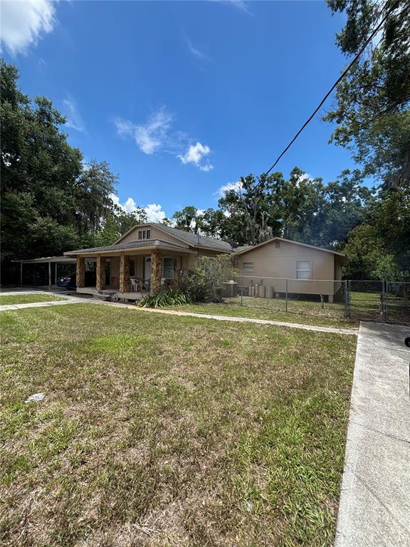 A single-story house with a stone-accented front porch and a detached carport — 13232 BLISSFIELD ROAD, ODESSA, FL