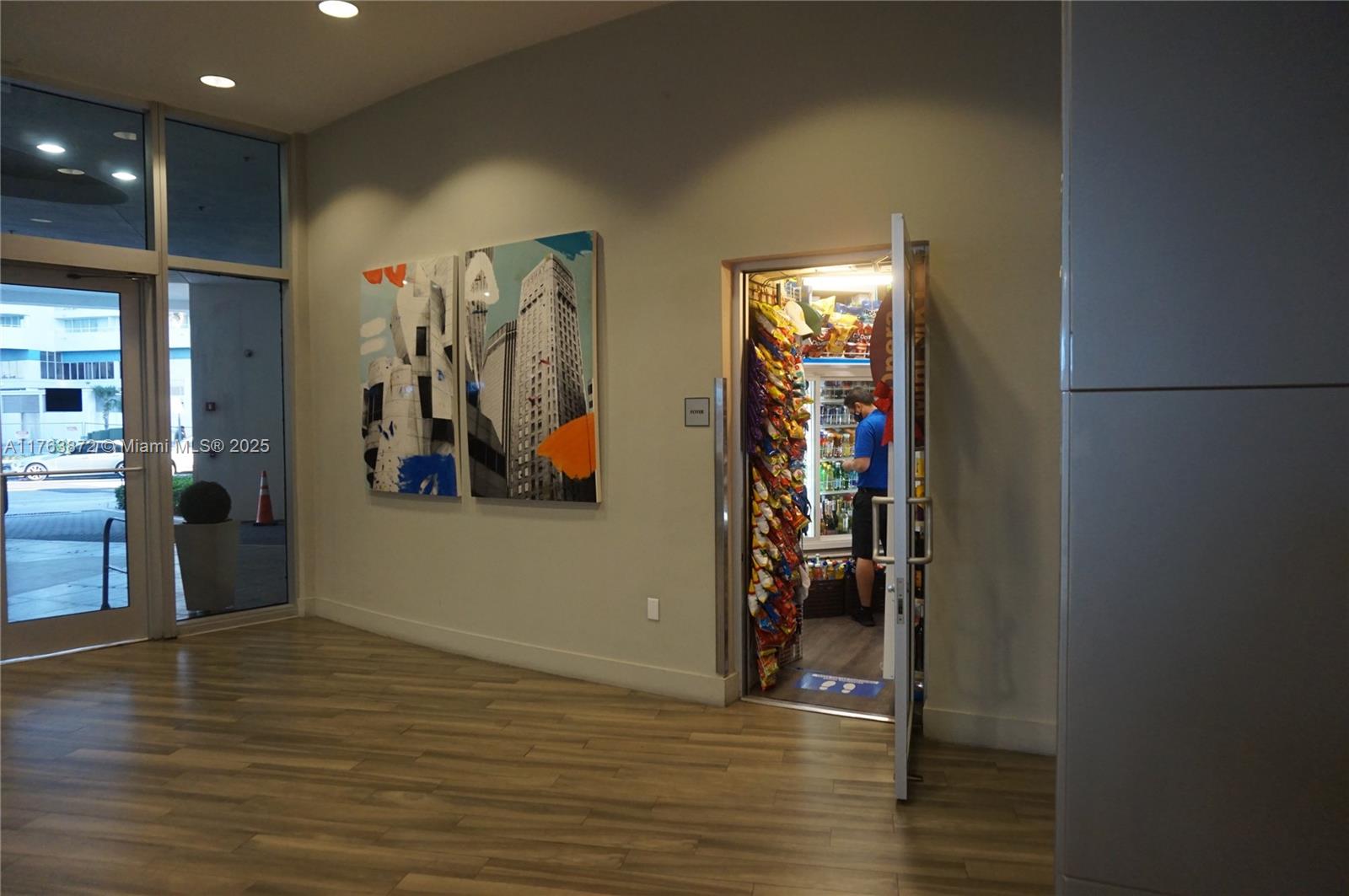 A modern lobby features wood-look flooring, abstract wall art, and a small snack pantry — 1750 N Bayshore Dr # 2215, Miami FL 33132, MIAMI, FL