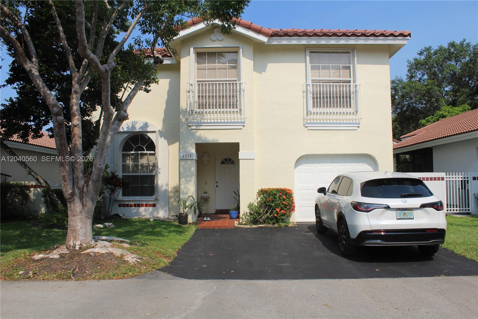 A two-story house with a white garage, a driveway, and two upper-level balconies — 1335 Seagrape Cir, Weston FL 33326, WESTON, FL