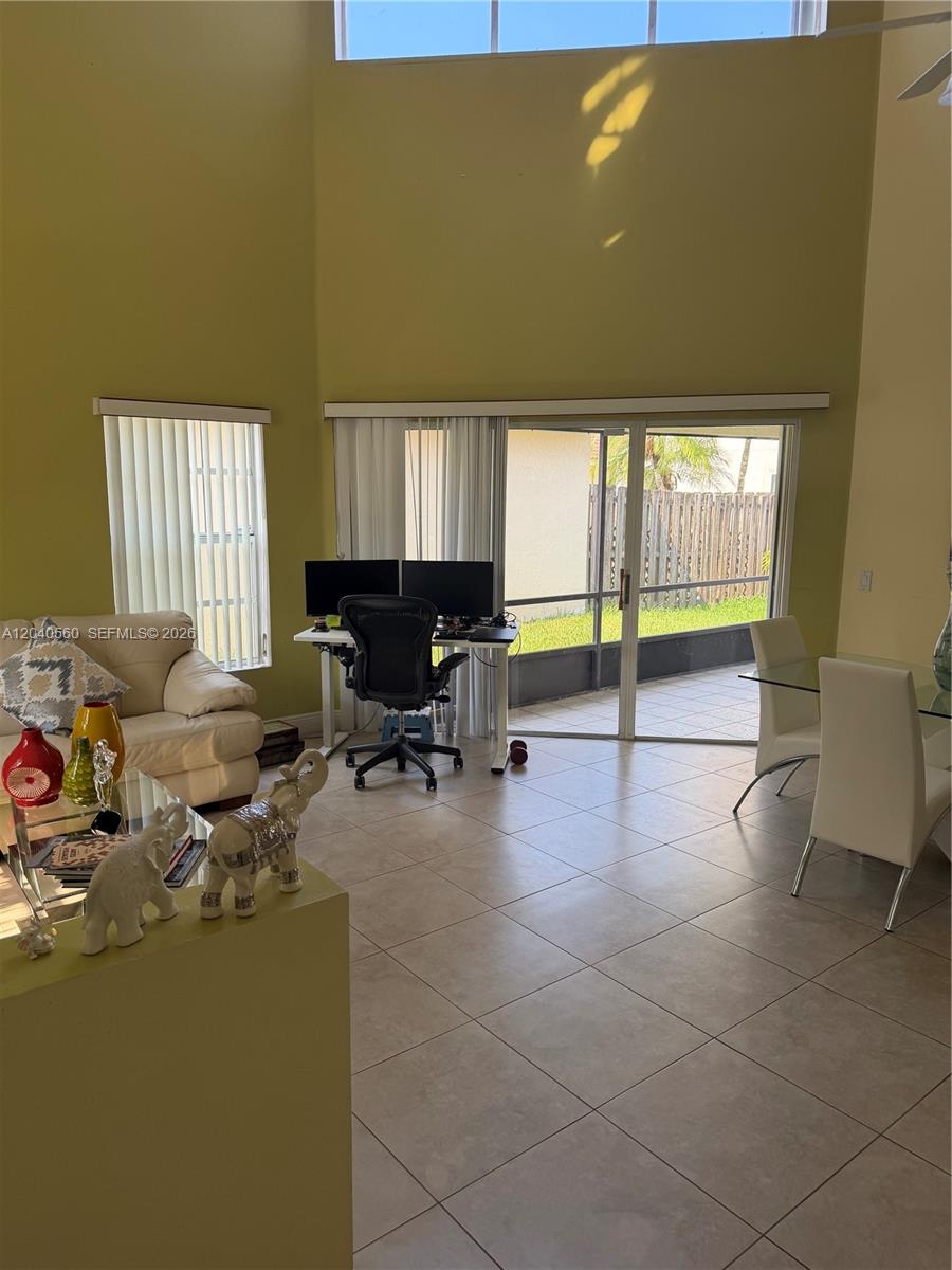 A living and dining area features tile flooring, high ceilings, and a sliding glass door — 1335 Seagrape Cir, Weston FL 33326, WESTON, FL