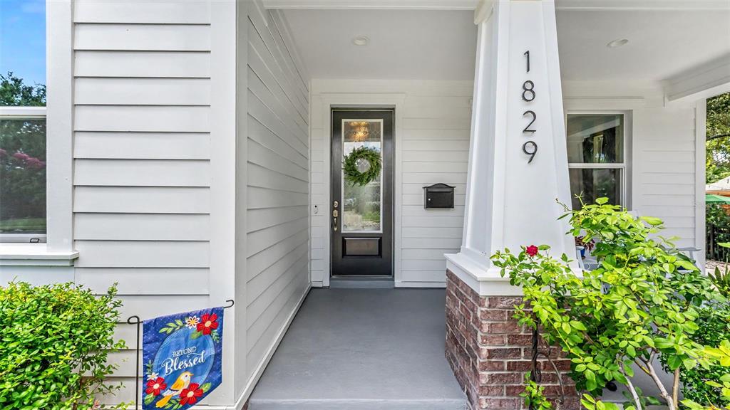 A front porch features a dark door, house numbers on a pillar, and a small flag — 1829 CHEROKEE TRAIL, LAKELAND, FL