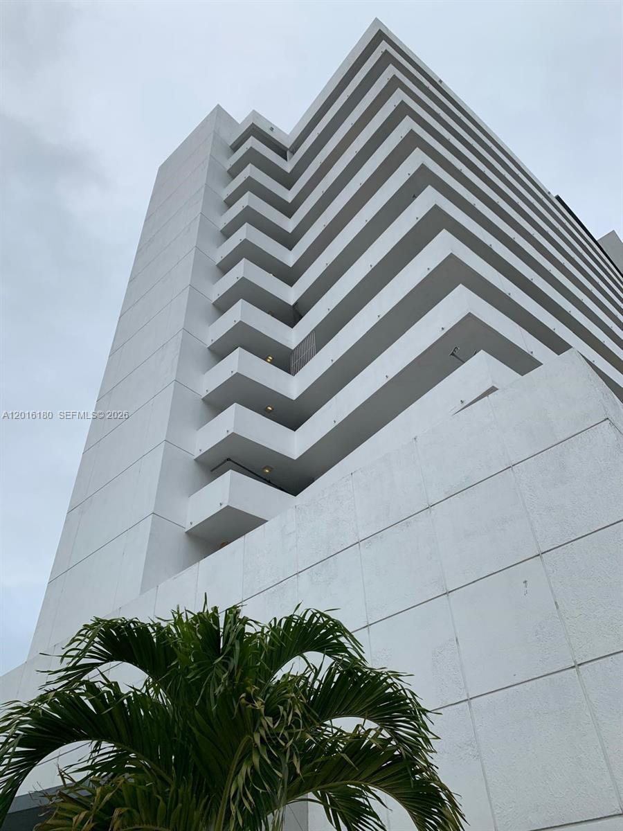 A low-angle view shows the white, tiered exterior balconies of a modern high-rise building — 36 NW 6th Ave # 1108, Miami FL 33128, MIAMI, FL