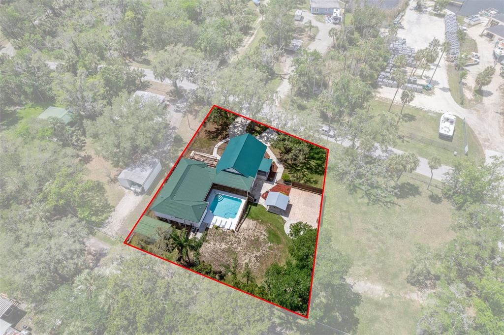 An aerial view shows a house with a green metal roof and a swimming pool — 5447 S BOULEVARD DRIVE, HOMOSASSA, FL