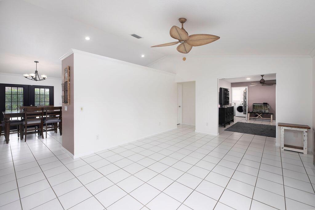 A bright, open-concept living area features white tile flooring, a ceiling fan, and a dining room — 14502 69th Street N, FL 33470, FL