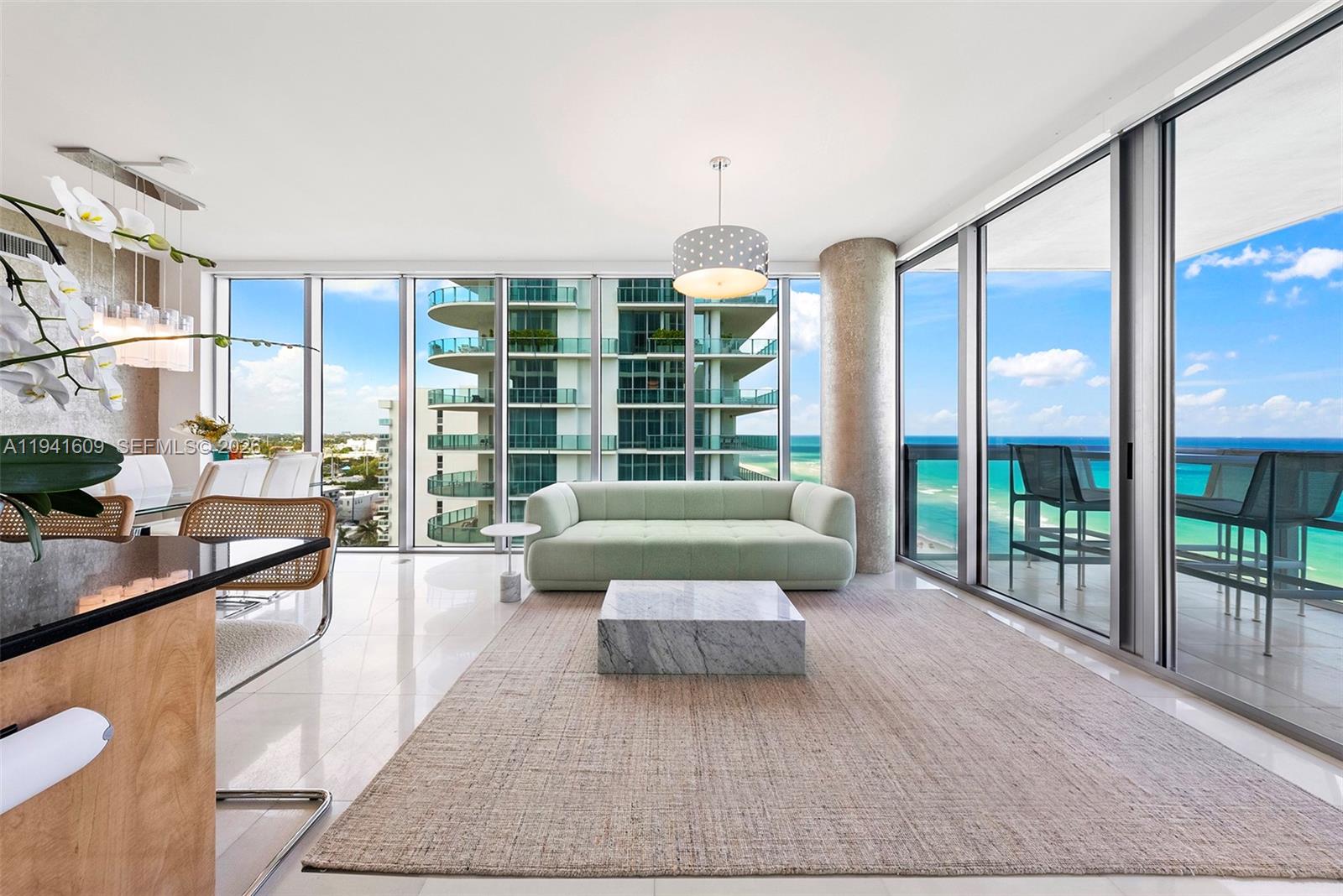 A modern living room features a light green sofa, marble coffee table, and ocean views — 6899 Collins Ave # 1205, Miami Beach FL 33141, MIAMI BEACH, FL