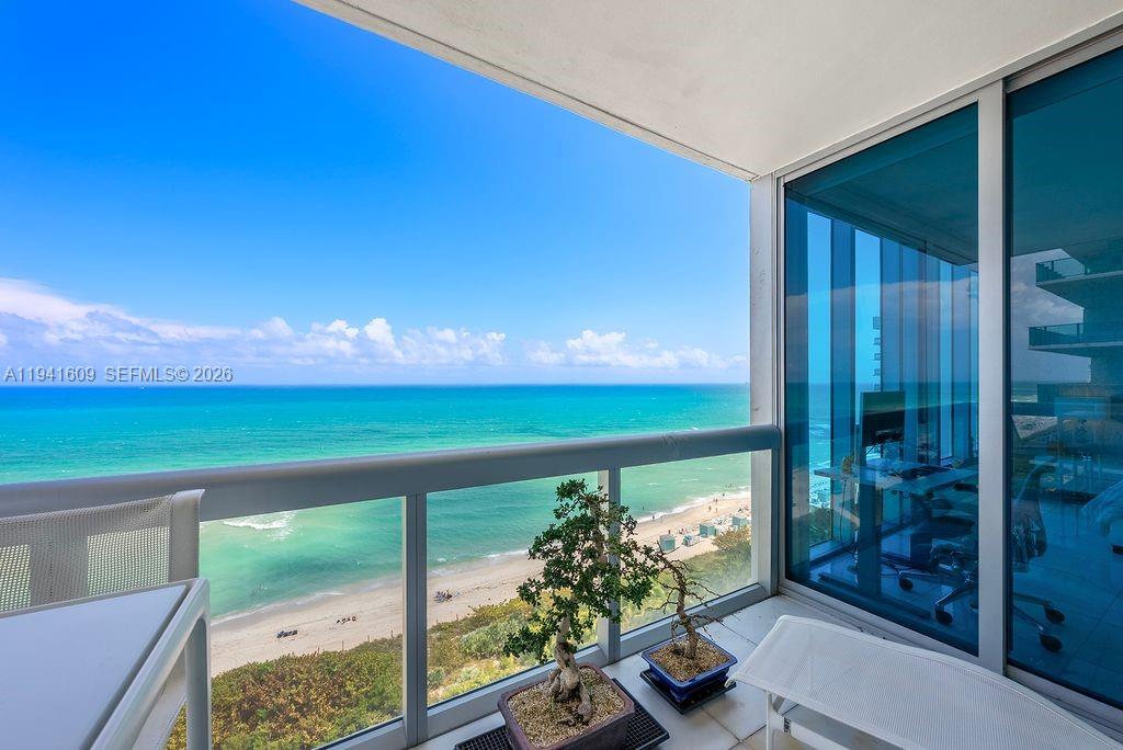 A balcony with two bonsai trees overlooks the ocean and a sandy beach — 6899 Collins Ave # 1205, Miami Beach FL 33141, MIAMI BEACH, FL