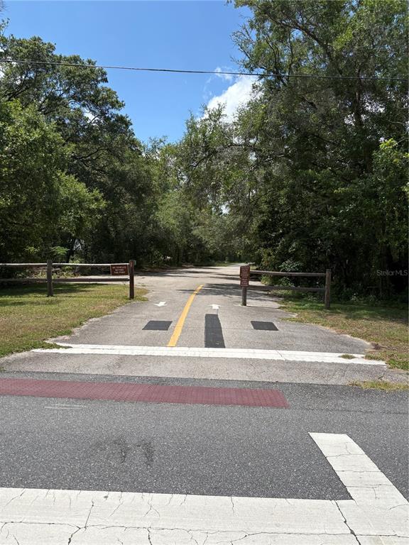 A paved trail entrance with wooden fencing and signage leads into a wooded area — 10965 N MATARO AVENUE, CITRUS SPRINGS, FL