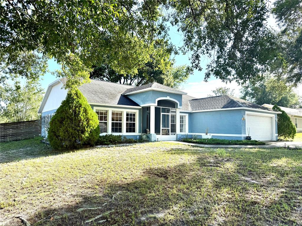A blue single-story house with a white garage and a screened front entryway — 3244 FIELDCREST TERRACE, DELTONA, FL