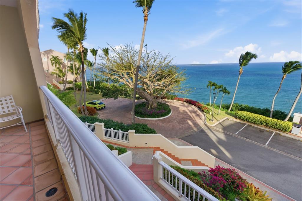 A balcony view overlooks a circular driveway, a large tree, and the ocean — Las Casitas I 1000 AVENUE EL CONQUISTADOR UNIT 5113-14-15, FAJARDO, PR