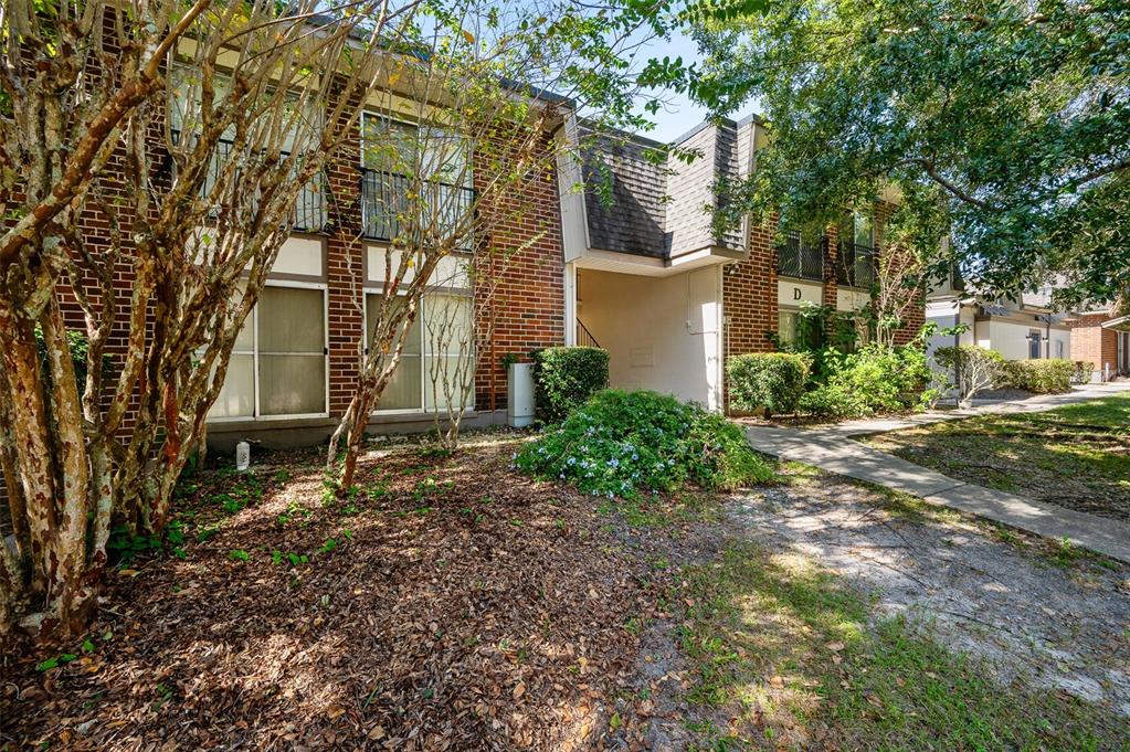 A two-story brick apartment building features a covered entryway marked with the letter D — 1700 SW 16TH COURT UNIT D24, GAINESVILLE, FL