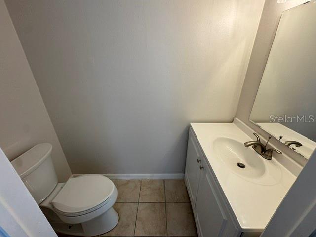 A small bathroom features a white vanity with a sink and a white toilet — 3960 WILLOW TRAIL RUN UNIT 1401, PORT ORANGE, FL