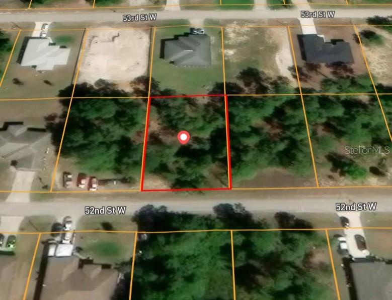 This is an aerial map view showing a vacant, wooded residential lot outlined in red — 2706 52ND STREET W, LEHIGH ACRES, FL
