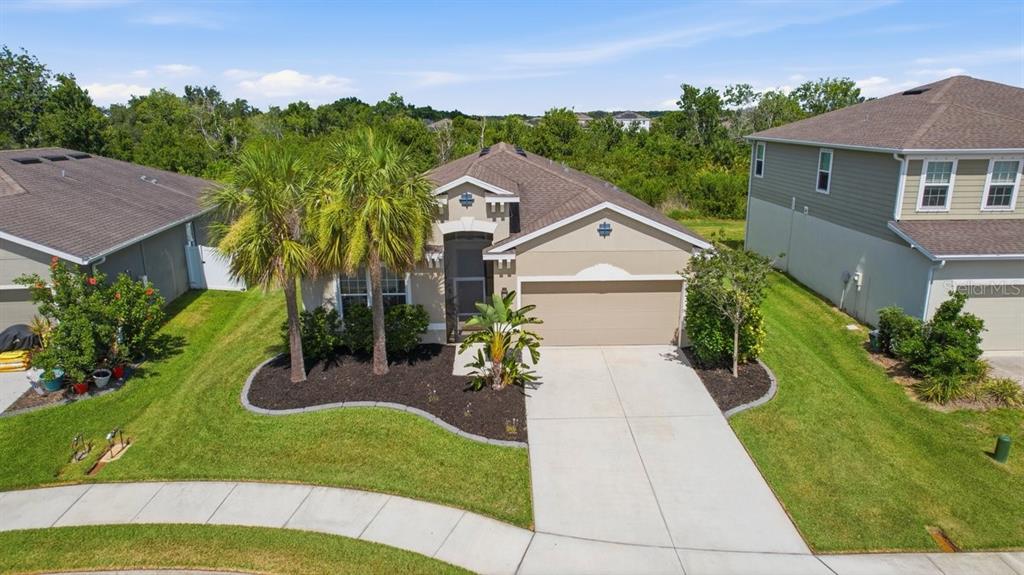 An aerial view shows a single-story suburban house with a two-car garage and palm trees — 5907 114TH AVENUE E, PARRISH, FL