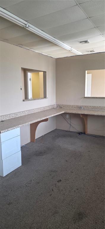 An office space features a long, L-shaped laminate countertop, white drawer unit, and carpeted flooring — 237 W BROAD STREET, GROVELAND, FL