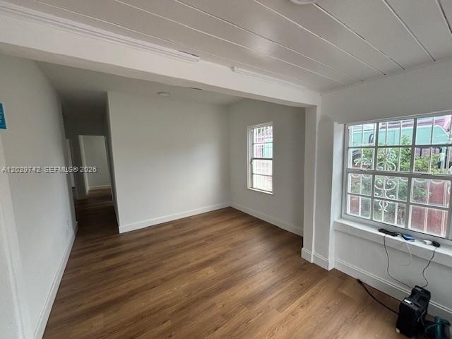 An empty room features light wood-look flooring, white walls, and a white plank ceiling — 34 NW 69th St, Miami FL 33150, MIAMI, FL