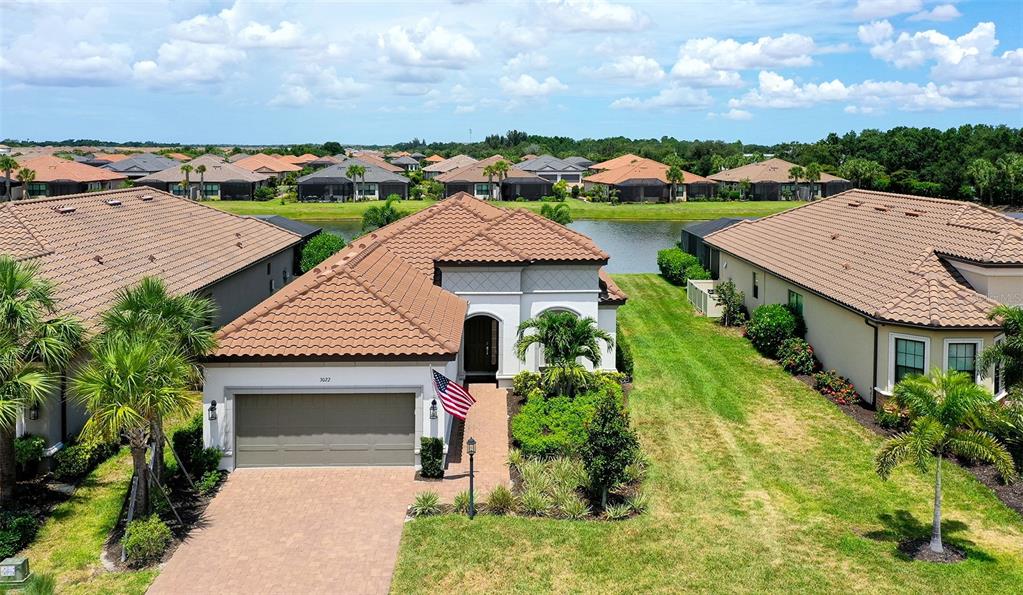 A single-story house with a two-car garage and a paved driveway at sunset — 3022 VITTORIO COURT, BRADENTON, FL