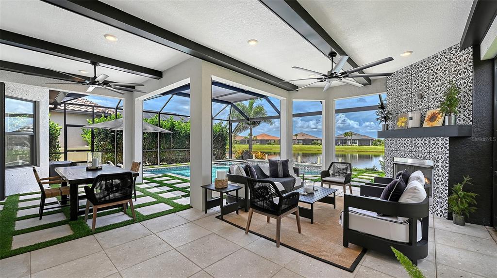 A swimming pool with a screened enclosure overlooks a lake and houses at sunset — 3022 VITTORIO COURT, BRADENTON, FL
