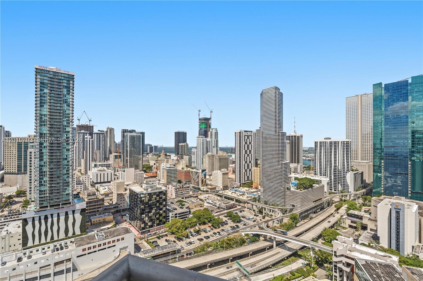 An elevated view of a dense urban skyline featuring numerous skyscrapers and highway overpasses — 350 S Miami Ave # 3307, Miami FL 33130, MIAMI, FL