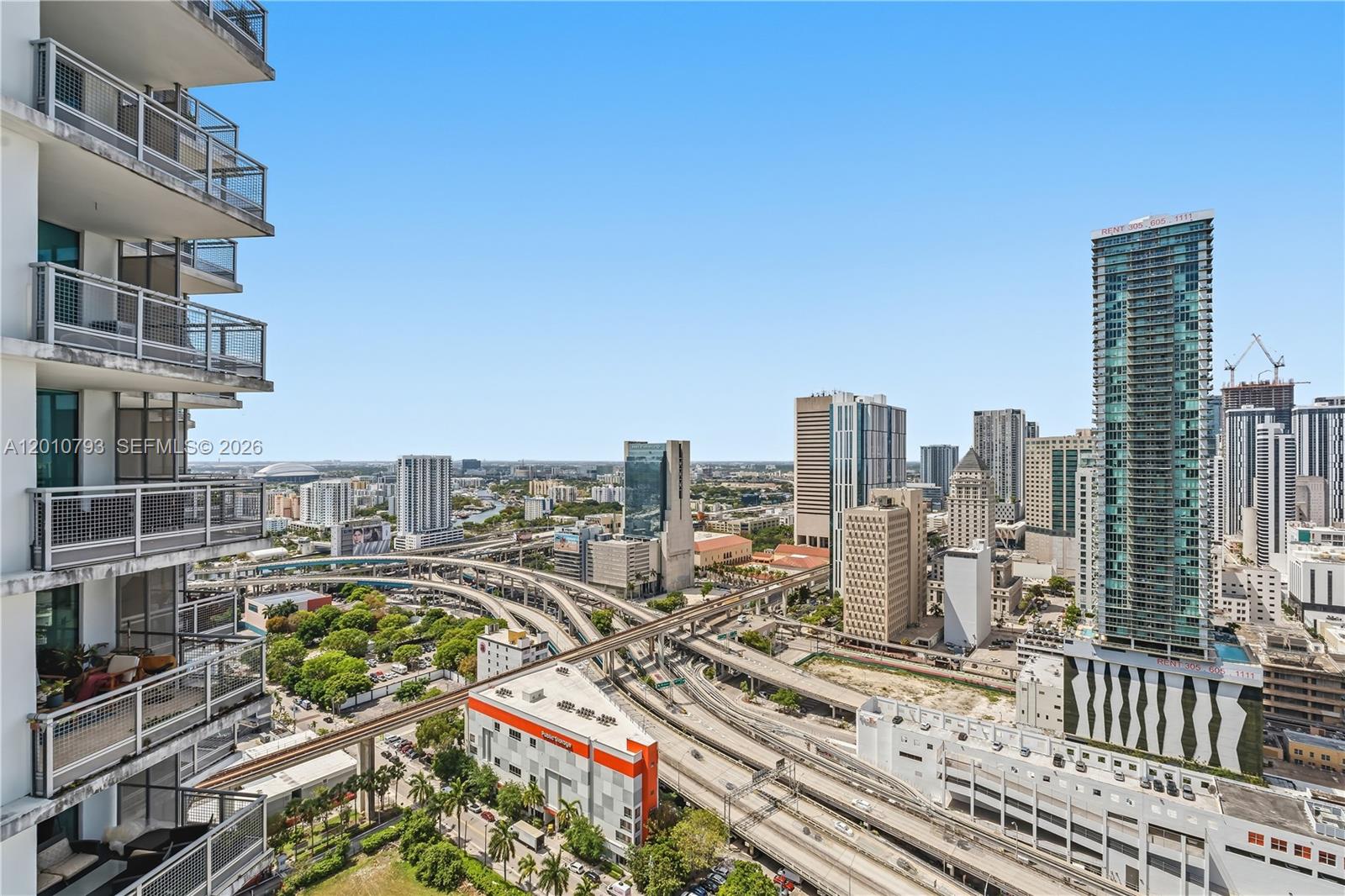 An elevated view of a city skyline featuring high-rise buildings, highway interchanges, and train tracks — 350 S Miami Ave # 3307, Miami FL 33130, MIAMI, FL