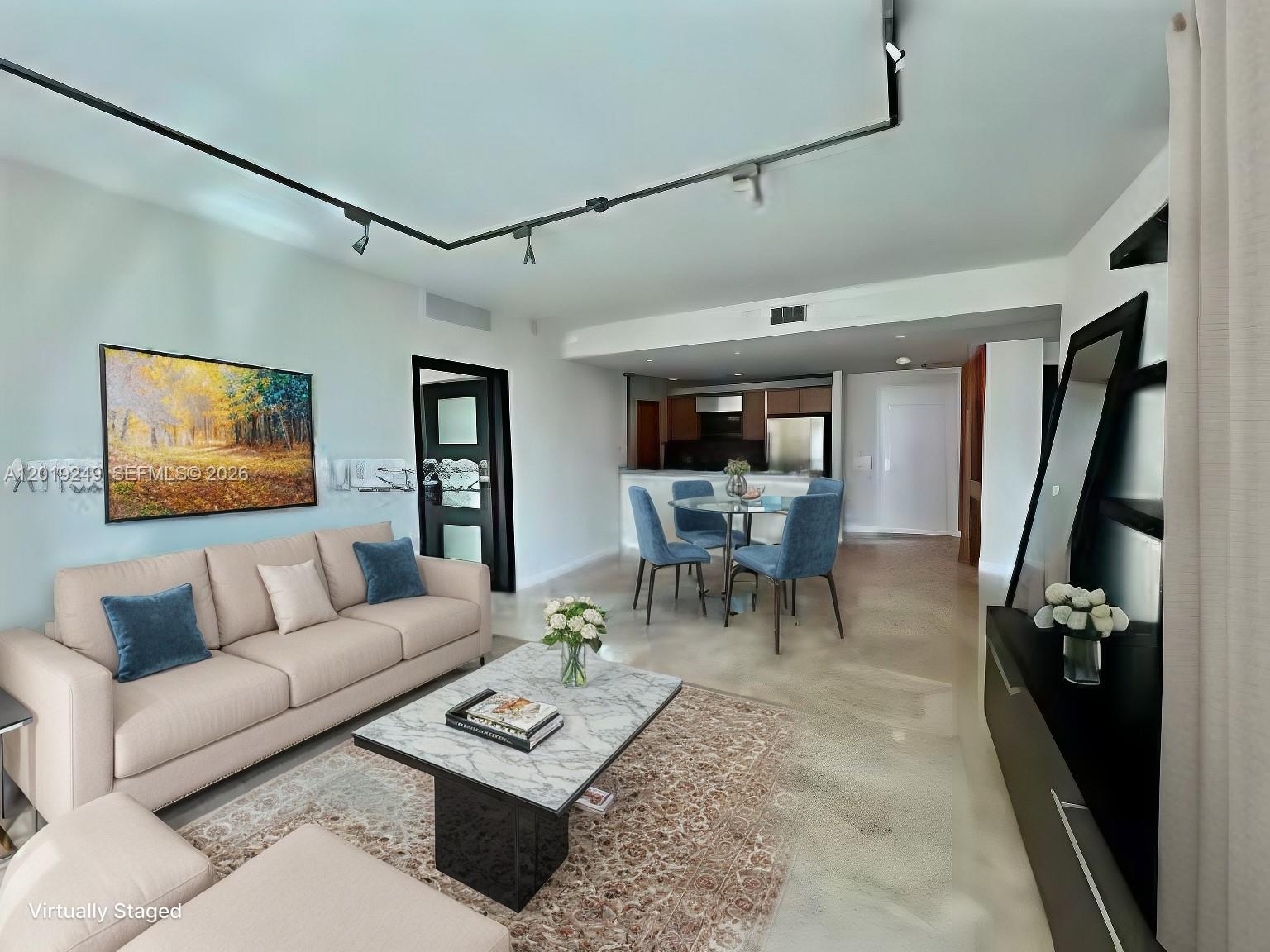 This living and dining room features a beige sofa, marble coffee table, and track lighting — 300 S Biscayne Blvd # 2606, Miami FL 33131, MIAMI, FL