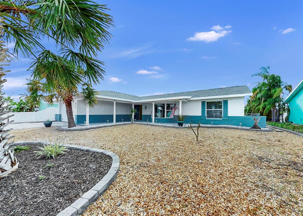 A single-story house with a teal and white exterior features a gravel front yard — 6512 SENEGAL PALM WAY, APOLLO BEACH, FL