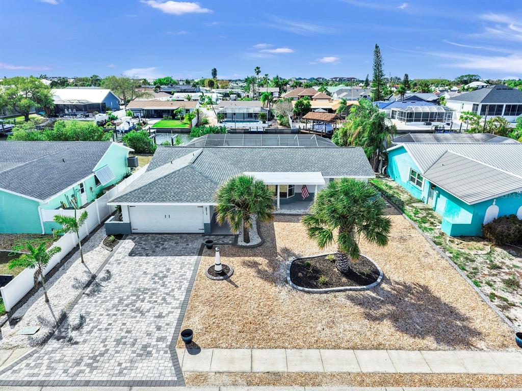 An aerial view of a single-story house with a paved driveway and gravel front yard — 6512 SENEGAL PALM WAY, APOLLO BEACH, FL