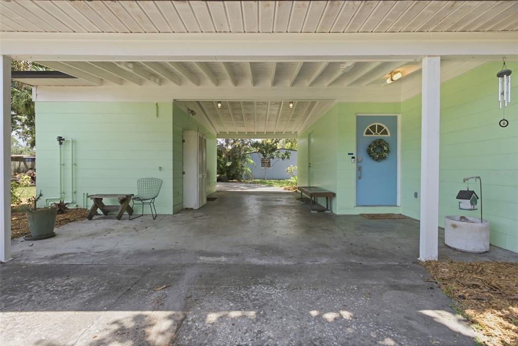 A light green house features a covered carport and a blue front door — 609 W RIVER DRIVE, TAMPA, FL